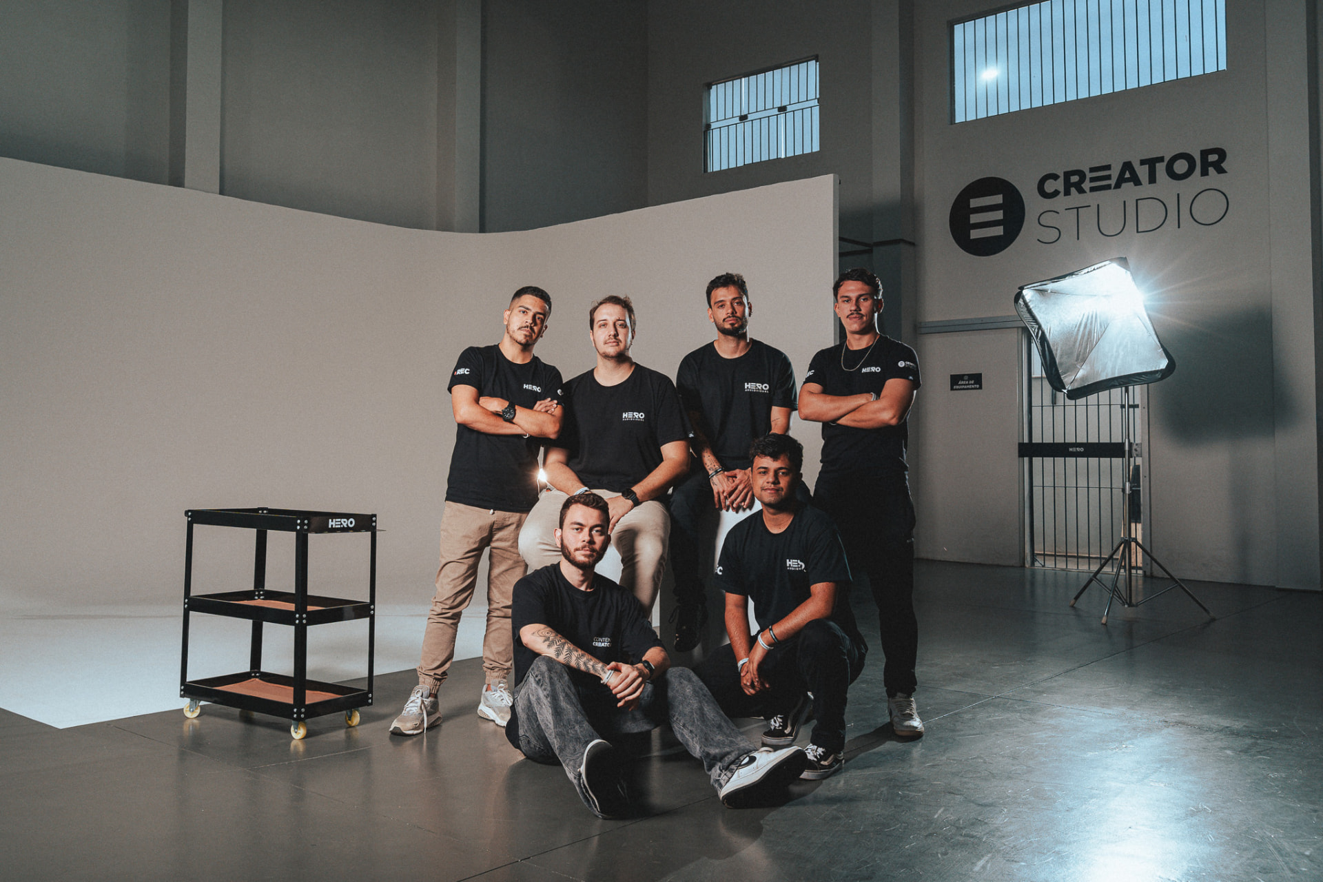 Equipe da Hero Audiovisual posando em estúdio industrial com fundo branco